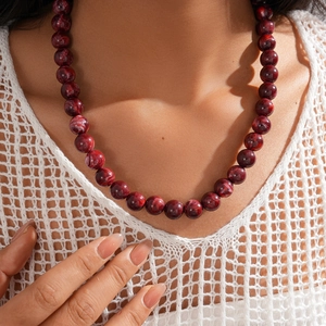 Detailed view of deep red acrylic marbled beads on a stylish bohemian necklace