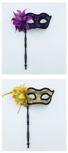 Detail of handheld masquerade masks with sequins, silk flowers and black plastic handles