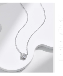 Detail shot of a square halo moissanite pendant on a slim sterling silver chain