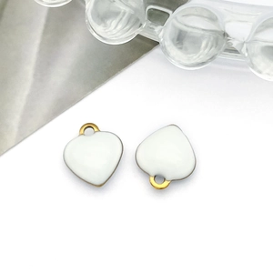 Macro detail of white enamel heart pendants with gold metallic edges for DIY jewelry making