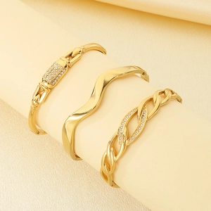 Détail de trois bracelets joncs en acier inoxydable plaqué or 18k avec cristaux