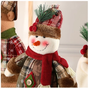 Close-up of a Christmas snowman doll with red plaid hat and cozy knit scarf detail