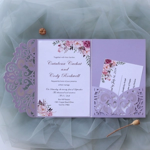 Close-up of laser-cut purple wedding invitation with floral insert and RSVP card set