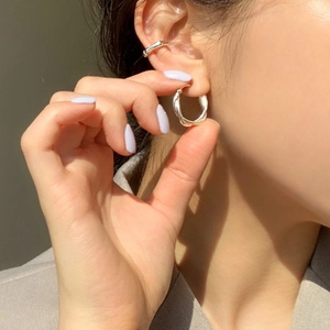 Close-up of 925 sterling silver twisted rope earrings and simple cuff stack on ear