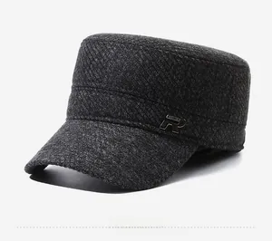 Detail view of dark grey textured wool flat cap with silver metal R logo on the side