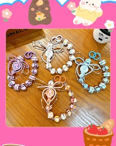 Vue détaillée de quatre bijoux de téléphone perlés colorés avec miroirs et nœuds.