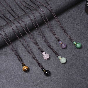 Detail showing natural tiger eye and malachite stones on hand-woven necklace cords