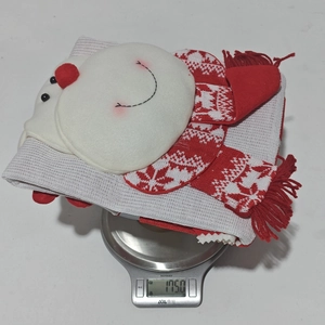 Detail der Gewichtsanzeige eines roten gestrickten Weihnachts-Schneemann-Stuhlbezugs