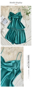 Close-up of emerald green satin camisole set with V-neckline and elastic waist shorts