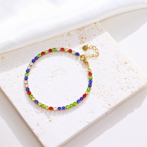Detailed close-up of golden evil eye bracelet with colorful round zircons on white silk