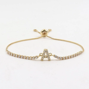 Macro detail of gold tennis bracelet with cubic zirconia paving and adjustable box chain
