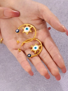 Detail of 18K gold-plated C-shaped earrings with enamel evil eye and sun motifs