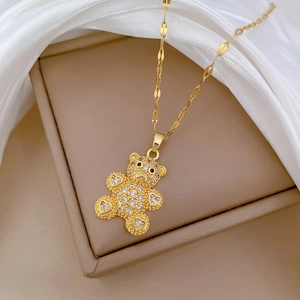 Close-up of a gold bear pendant with sparkling crystals on a premium leather jewelry box