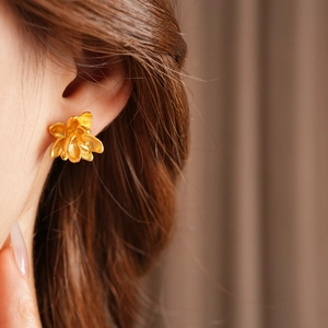 Detailopname van gouden lotusbloem oorsteker gedragen door model voor vintage look
