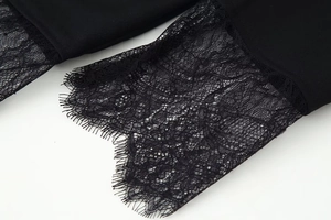 Detailed macro view of black fabric with delicate eyelash lace stitching on the sleeve