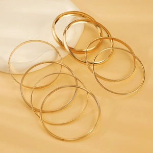 Close-up of bohemian gold alloy multi-layer bangle set with textured geometric patterns