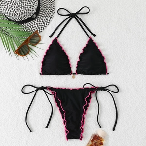 Halter bikini set with pink ruffle trim and gold pendant on a beach-themed background