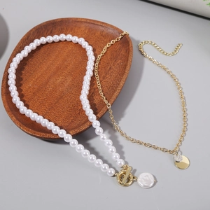 Close-up of layered baroque pearl necklace with golden OT clasp on wooden tray