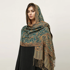 Detail of blue-green paisley cashmere-like shawl with golden floral patterns and fringes