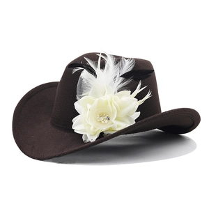 Detail of dark brown felt cowboy hat with cream flower, feathers and white mesh veil