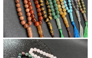 Macro detail of natural crystal prayer beads featuring smooth textures and silk tassels
