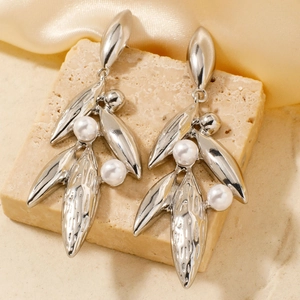 Elegant silver leaf drop earrings with white pearls on a minimalist stone background