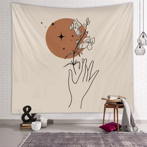 Detail of bohemian tapestry with minimalist hand art and terracotta sun on white wall