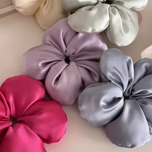 Elegant silk floral scrunchies in rose, purple and green colors on white background