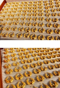 Macro detail of bulk gold twisted texture hoop earrings on white foam display tray