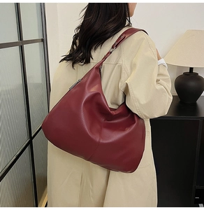 Detailansicht der burgunderroten Hobo-Tasche mit Kieselleder-Struktur und breitem Gurt