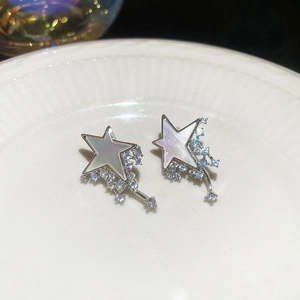 Close-up of star-shaped earrings with mother-of-pearl and sparkling zircon stones