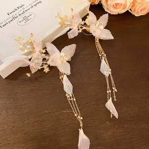 Détail de pinces à cheveux fleur en maille rose avec pompons perles et strass