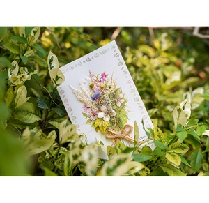 Close-up of handmade greeting card with dried flower bouquet and twine bow detail