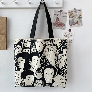 Dettaglio di borsa tote in tela con volti di cartoni animati appesa a una parete retrò