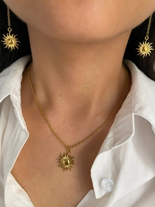 Detail of 18K gold plated sun necklace and stud earrings set worn by a female model