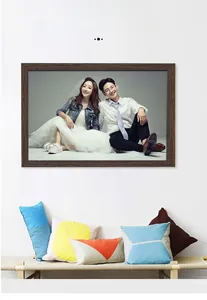 Detail of solid dark wood photo frame on wall with vibrant pillows on a bench