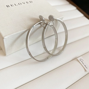 Close-up of silver minimalist round hoop clip-on earrings with soft transparent pads