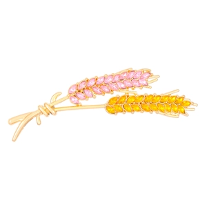 Close-up of pink and yellow rhinestone wheat stalks on a fine gold metal brooch