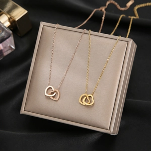 Interlocked double heart necklace in rose gold and gold finishes on a silk jewelry box