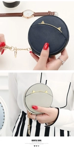 Detail of round mini coin purse with metal cat ears and premium leather texture