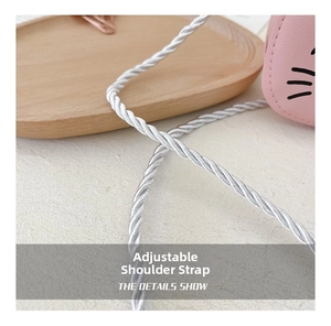 Detail of pink cat-themed bag with silver twisted rope shoulder strap for girls