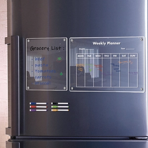 Magnetic acrylic weekly planner and grocery list set on black fridge with colored pens