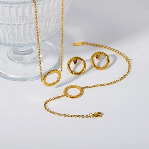 Macro detail of gold hammered texture necklace, bracelet and earring jewelry set for women