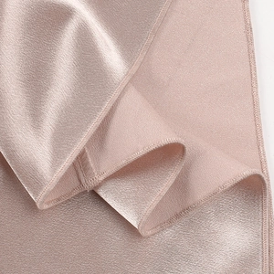 Vue macro détaillée du tissu satiné or rose avec un éclat soyeux et une texture fine