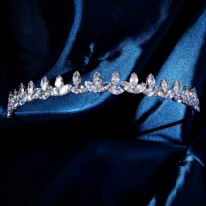 Macro detail of silver crown headband with marquise zircons on blue silk background