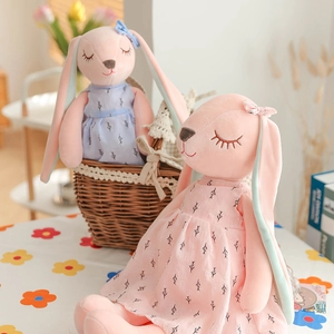 Pink and light blue plush bunny dolls wearing floral dresses in professional still life shot
