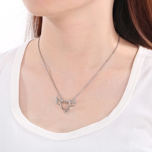 Detail of silver angel wing heart pendant necklace worn on neck for length display