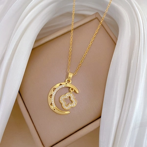 Golden moon and clover necklace with sparkling diamonds on elegant silk fabric