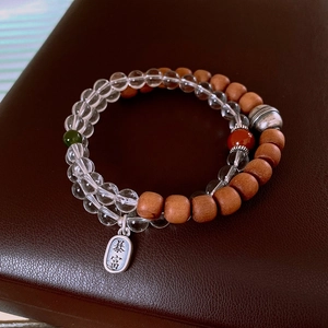 Macro detail of S925 silver tag and stacked crystal beads with sandalwood bracelets