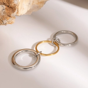 Anelli intrecciati in acciaio inossidabile oro 18k e argento su uno sfondo bianco